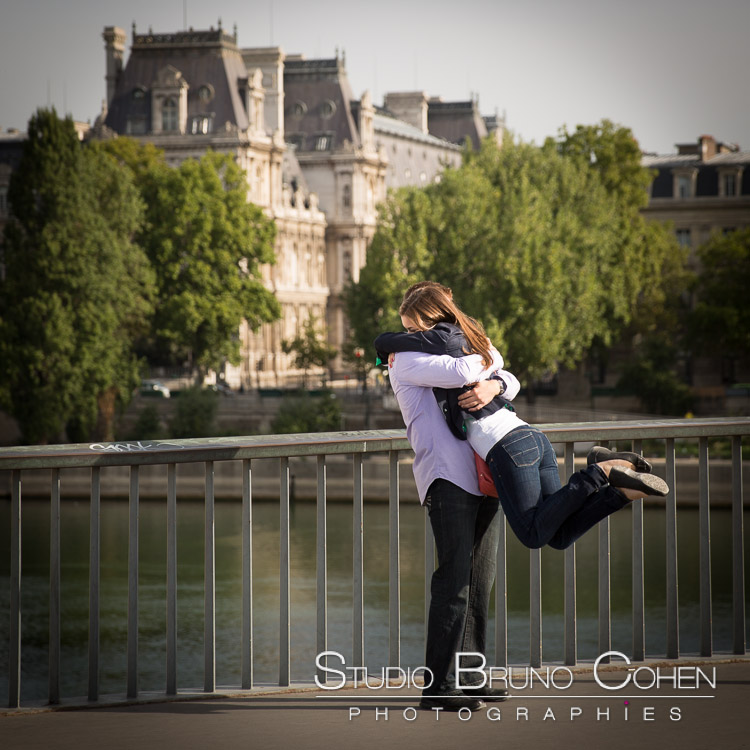 surprise proposal in paris from saint louis bridge couple hugging in love lady jump kiss fashion at sunrise