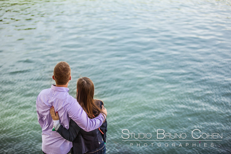 portrait hugging couple in love from quai de seine front of blue sea love engagement session