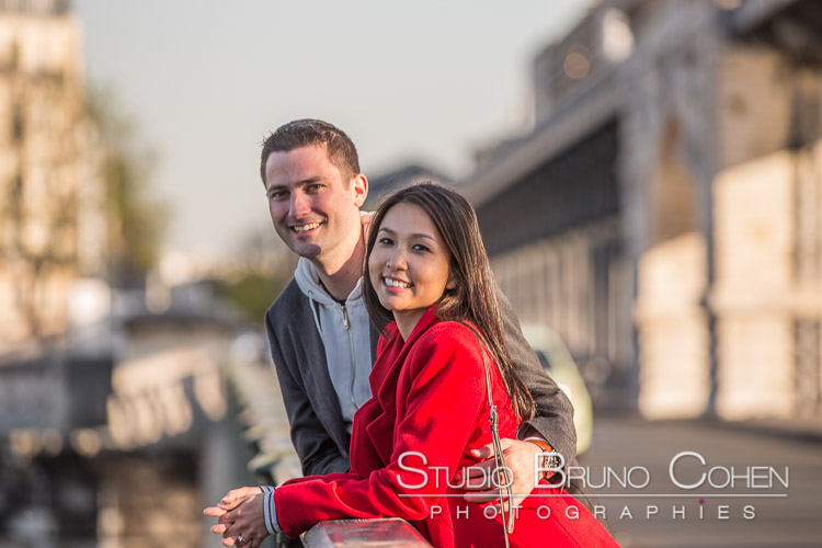 portrait couple hugging from quai de seine near Eiffel Tower at sunset lasian lady in red dress 