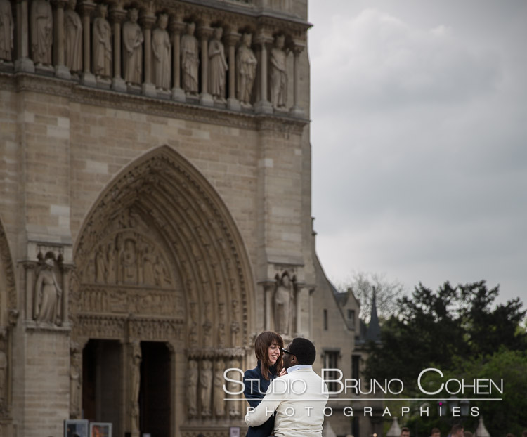 portrait couple in love face to face front of notre dame cathedral blue sky proposal in paris