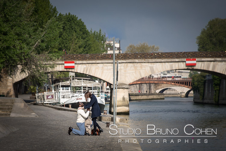 surprise proposal in paris couple near notre dame cathedral spring at sunrise emotions smile happy
