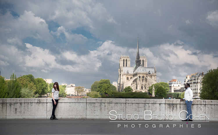 fashion portrait couple in love stand on bridge front of notre dame cathedral at sunrise blue sky 