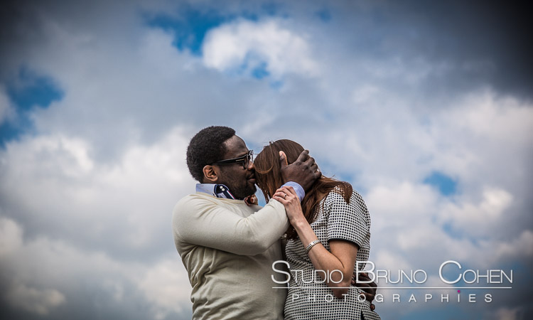 portrait couple kissing on forehead love from quai de seine near Eiffel Tower in paris blue sky