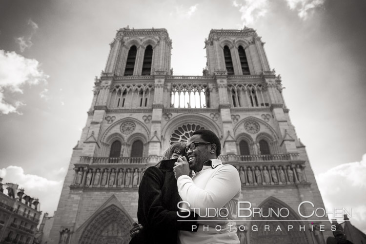 portrait couple in love standing front of notre dame cathedral in paris black and white 