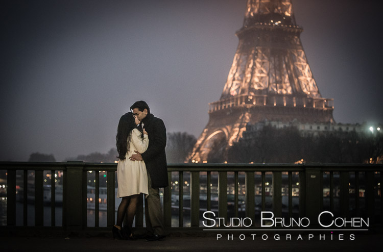 portrait kissing couple stand from bir hakeim bridge front of Eiffel Tower in paris at night winter 