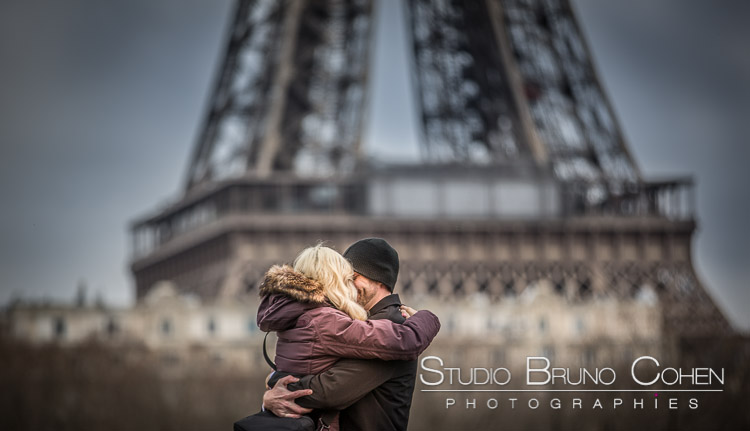 portrait kissing couple front of Eiffel Tower in paris at winter valentine day
