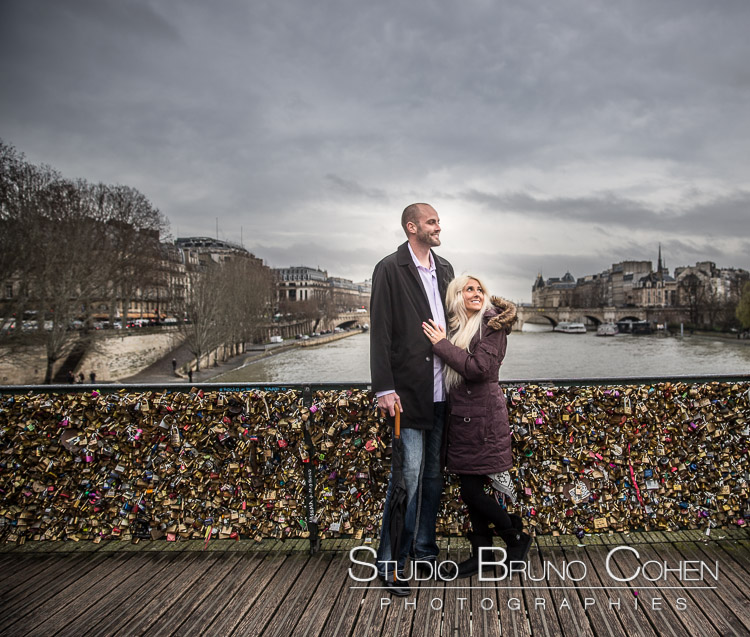 portrait hugging couple from lock bridge in paris winter Valentine's Day love smile happy emotions 