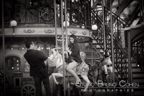 portrait couple take photo lady riding on horse from carousel Eiffel Tower in paris black and white