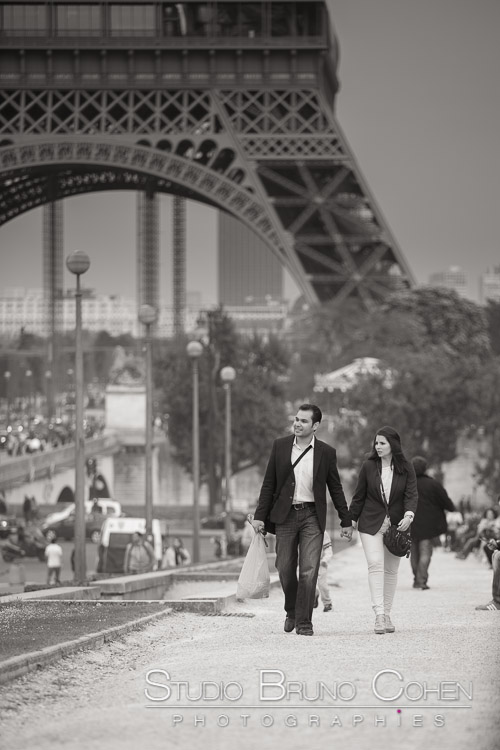 portrait couple hand in hand walk on Trocadero front of Eiffel Tower black and white paris proposal 
