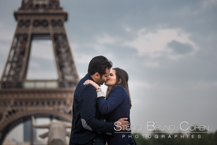 portrait kissing couple from paris front of Eiffel Tower blue sky emotions smile 