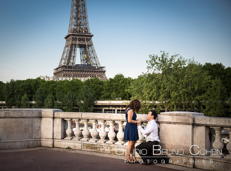 surprise proposal in paris couple in love emotions from Bir Hakeim bridge front of Eiffel Tower at sunrise