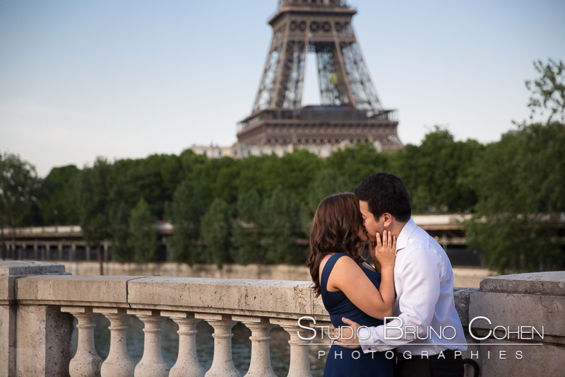 portrait kissing couple from Bir Hakeim bridge front of Eiffel Tower at sunrise proposal in paris emotions