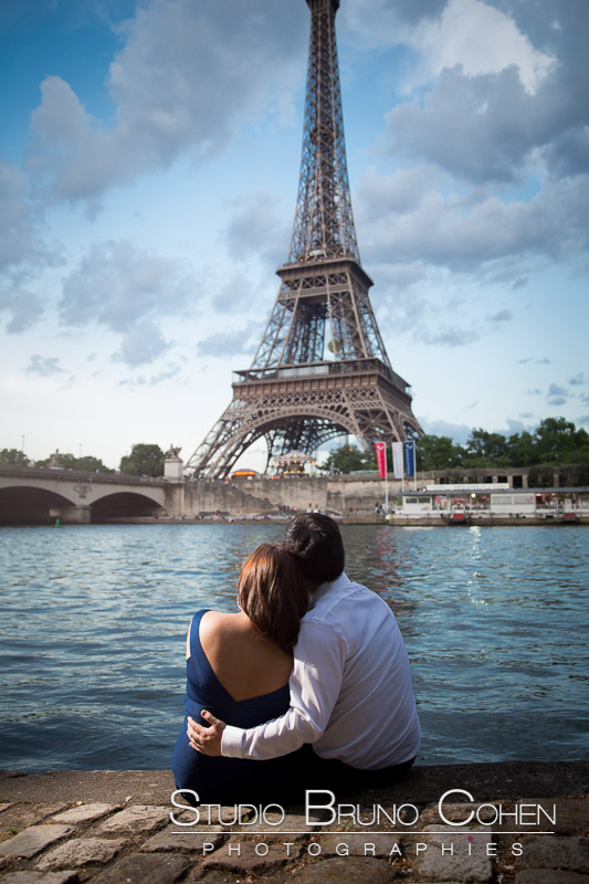 best portrait hugging couple from quai de seine front of Eiffel Tower in paris at sunrise blue sky summer proposal