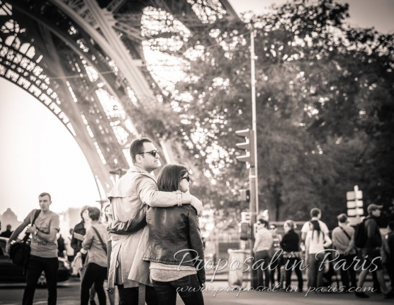 hugging couple front of eiffel tower black and white proposal in paris