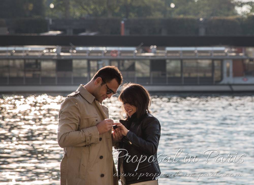 proposal in paris couple look engagement ring front eiffel tower 