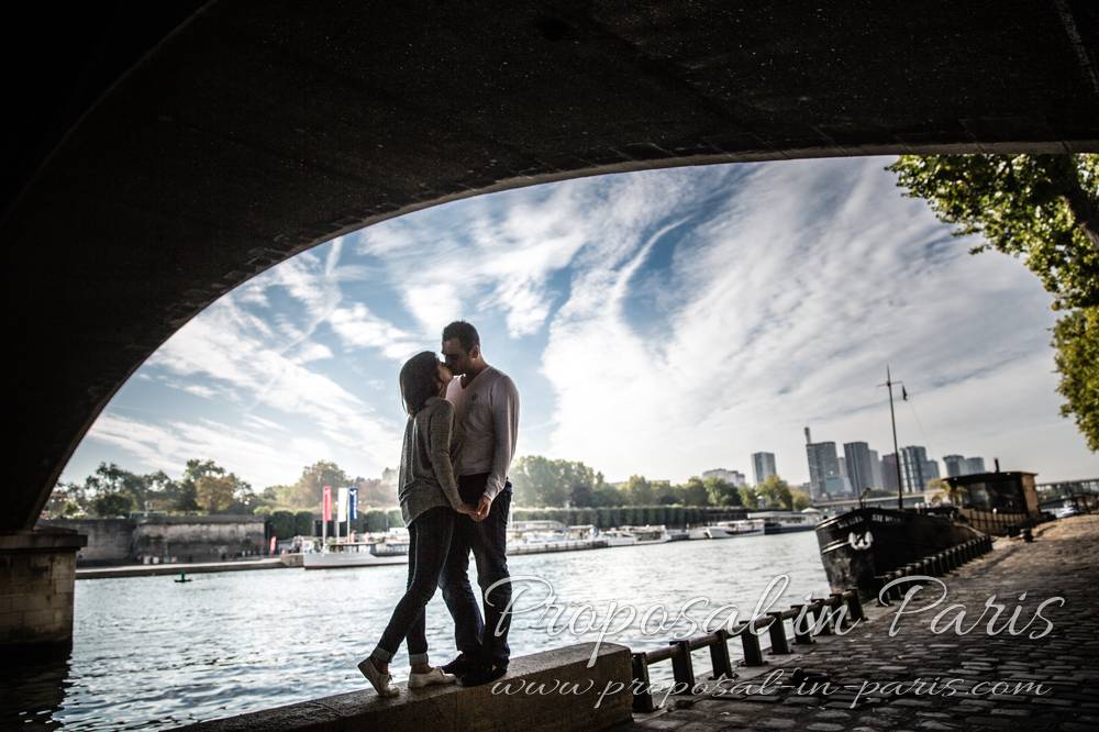 kissing couple under bridge in paris front of eiffel tower 