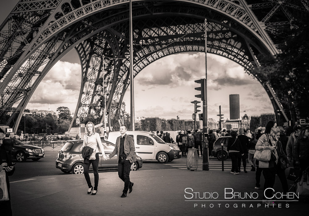 couple in love hand in hand walk in paris front of eiffel tower black and white