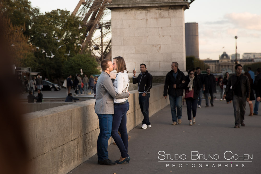 kissing couple in paris front of eiffel tower at sunset