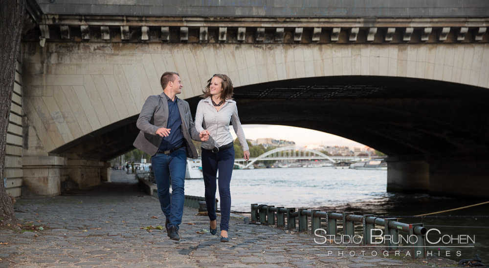 jumping couple in paris from quai de seine at sunset love smile