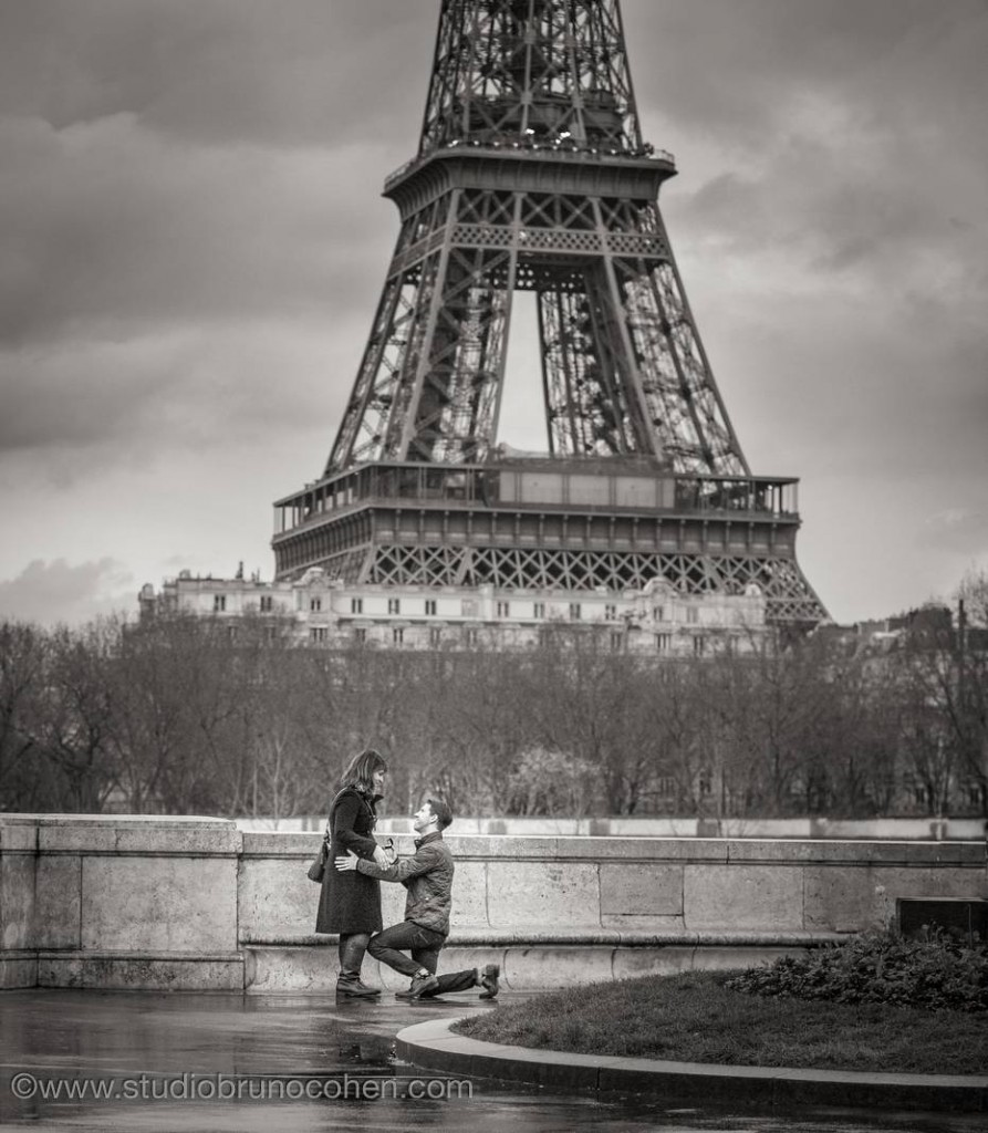 surprise proposal in paris couple in love front of Eiffel Tower black and white emotions happy funny smile 