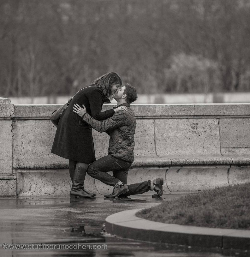 surprise proposal in paris couple kissing engagement session near Eiffel Tower at winter black and white 