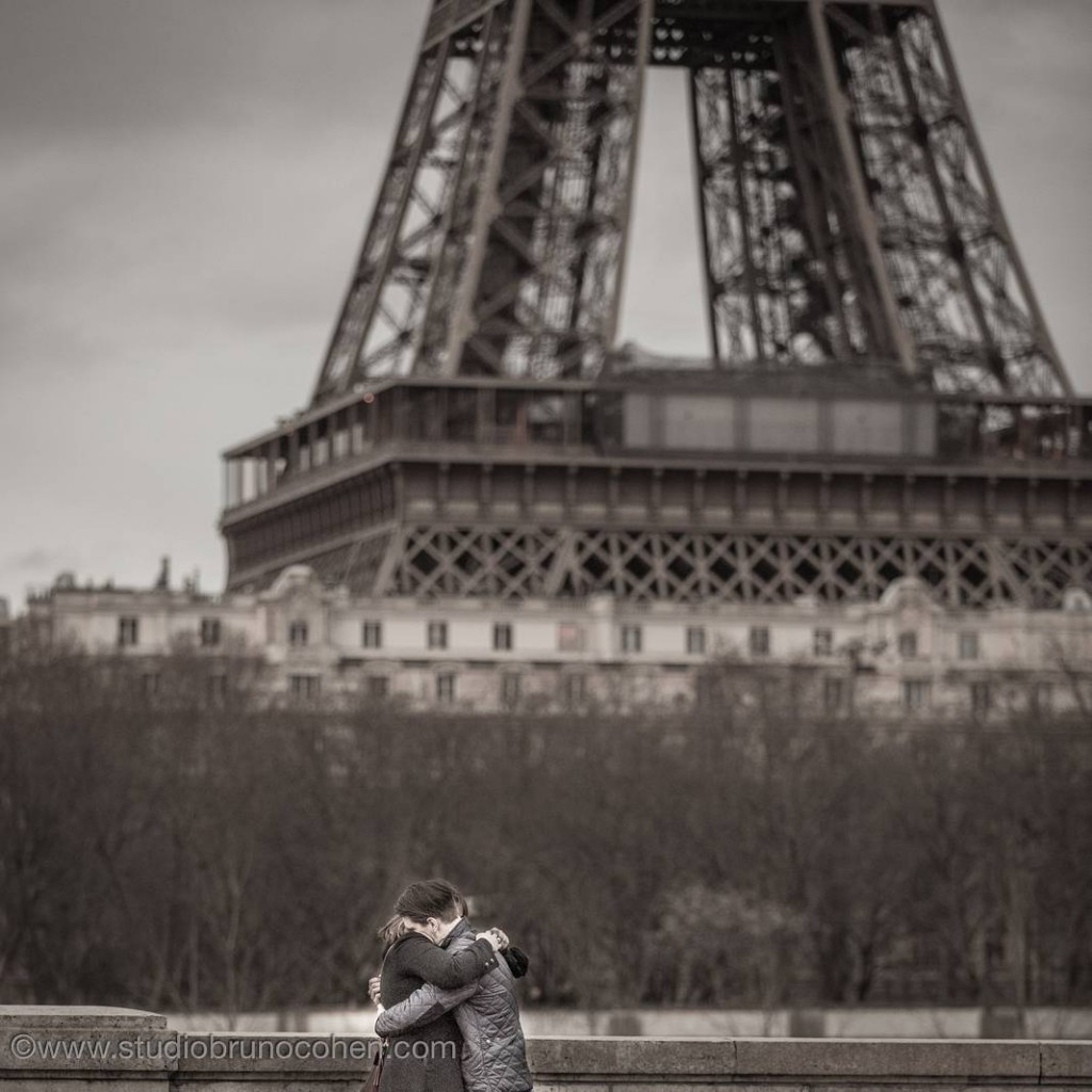 portrait hugging couple in love front of Eiffel tower engagement session at night winter black and white 
