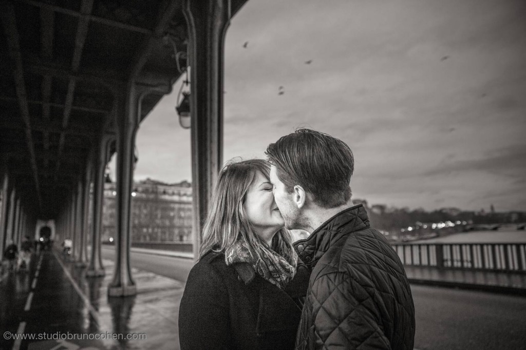 portrait kissing couple from bir hakeim bridge near Eiffel Tower proposal in paris black and white at night winter