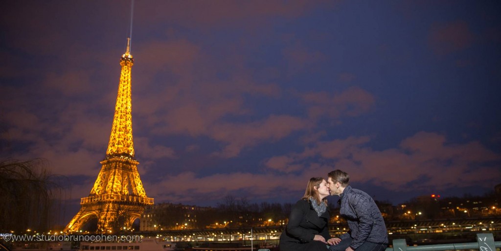 portrait kissing couple from quai de seine front of Eiffel Tower at sunset winter night proposal in paris 