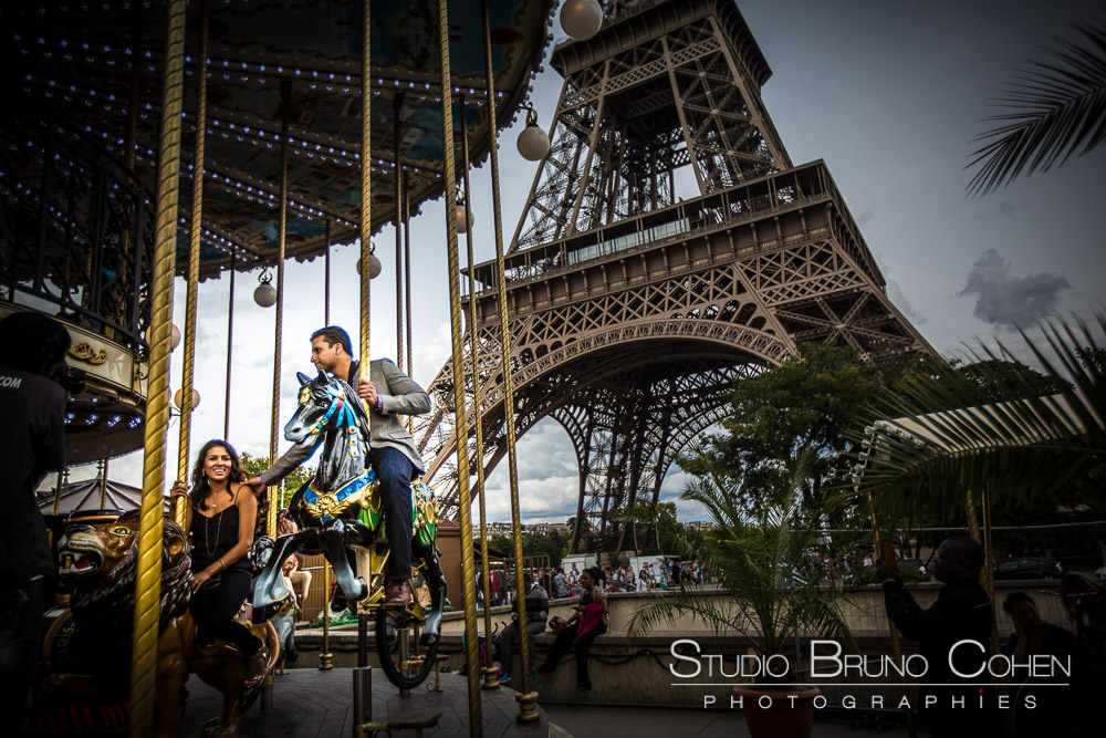proposal in paris couple rigind horses from eiffel tower carousel at summer