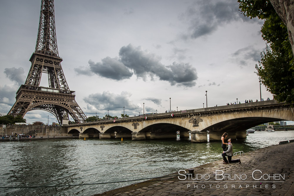 surprise proposal in paris front of eiffel tower on quai de seine couple in love