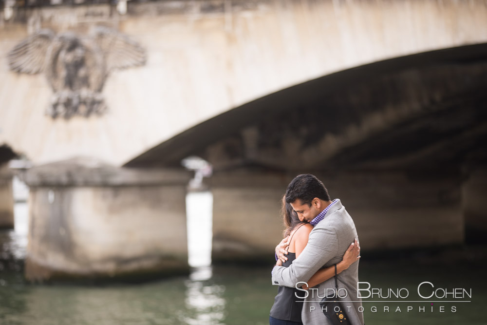 surprise proposal in paris front of eiffel tower on quai de seine couple hugging in love