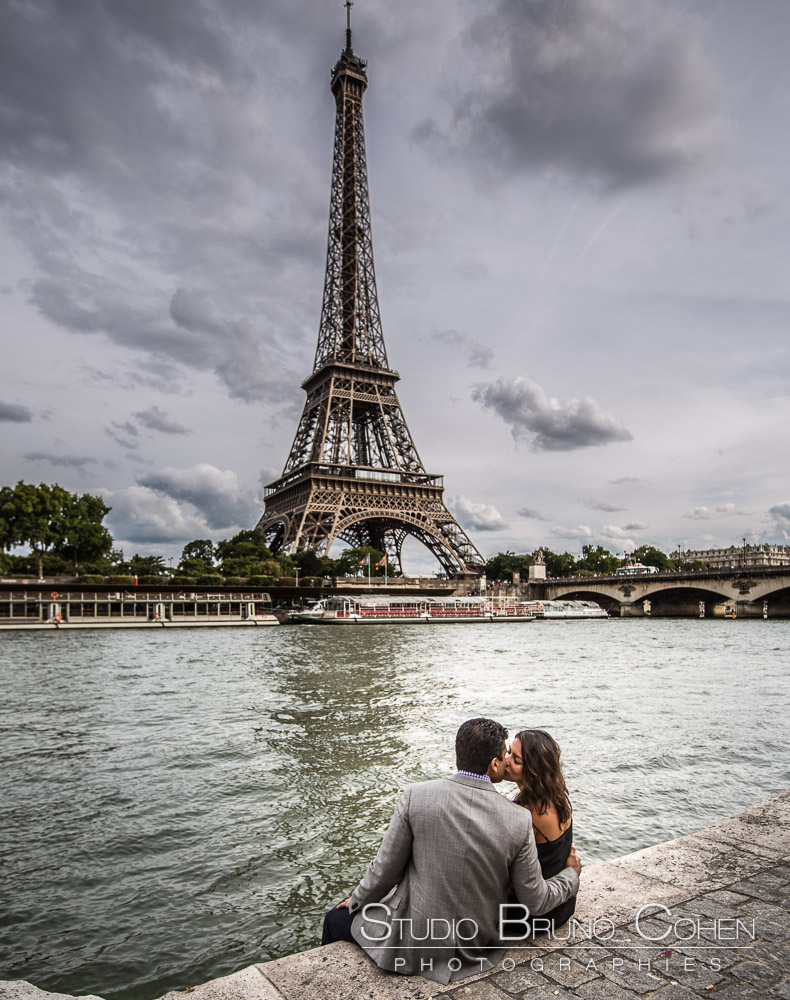 couple kiss in paris proposal front of eiffel tower at summer blue sky