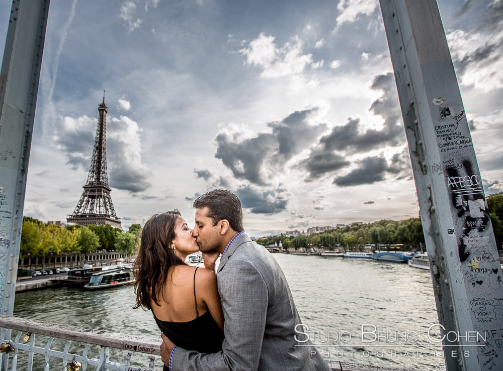 couple kiss in paris from bebilly walkway front of eiffel tower at sunset summer blue sky emotions