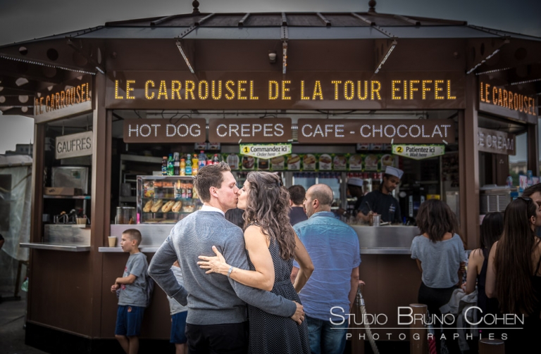 kissing couple in paris on eiffel tower carousel proposal surprise portrait kiss love 