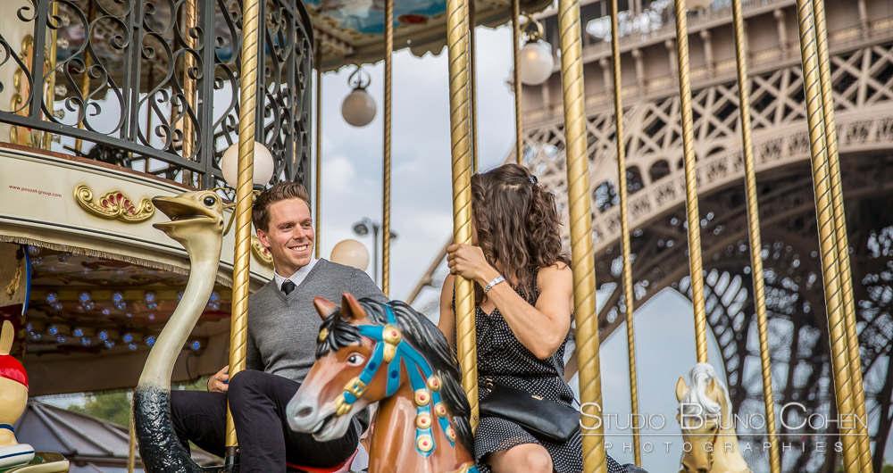 couple riding on horses at eiffel tower carousel proposal in paris