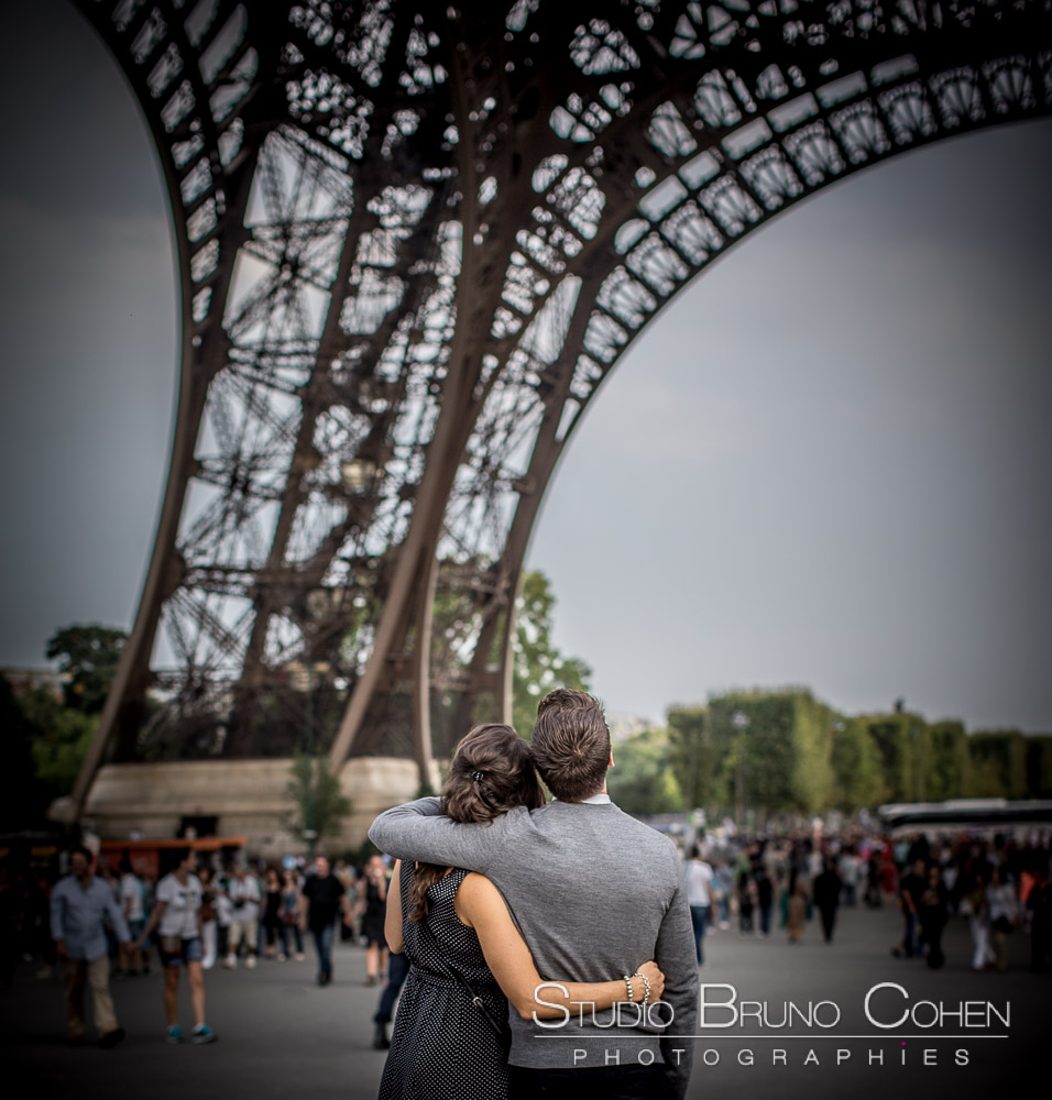 couple hugs standing front of eiffel tower 