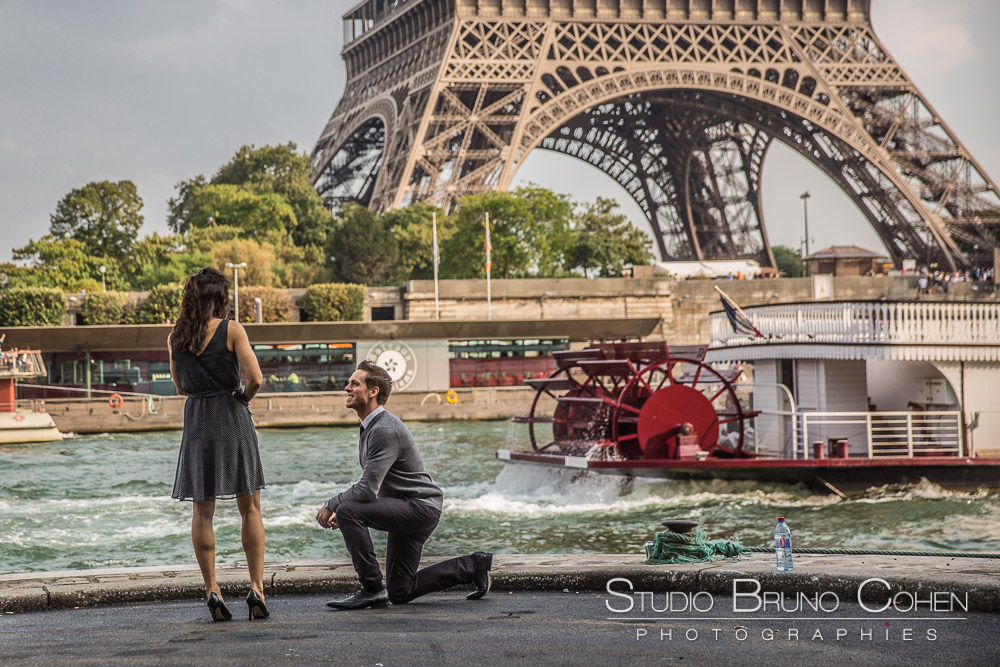 surprise proposal in paris front of eiffel tower at summer blue sky couple in love emotions