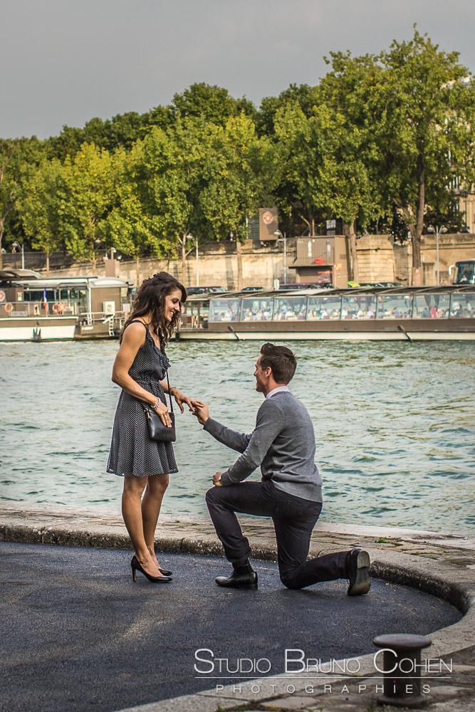 surprise proposal in paris at summer from quai de seine near eiffel tower couple in love 