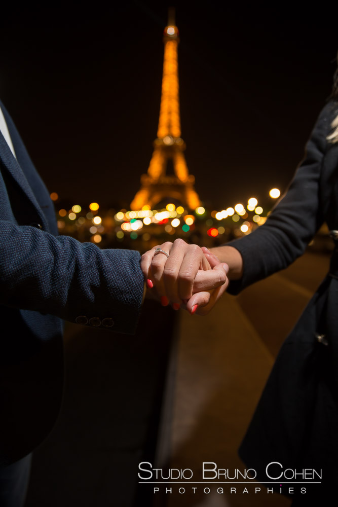 proposal in paris focus engagement ring at night front of eiffel tower 