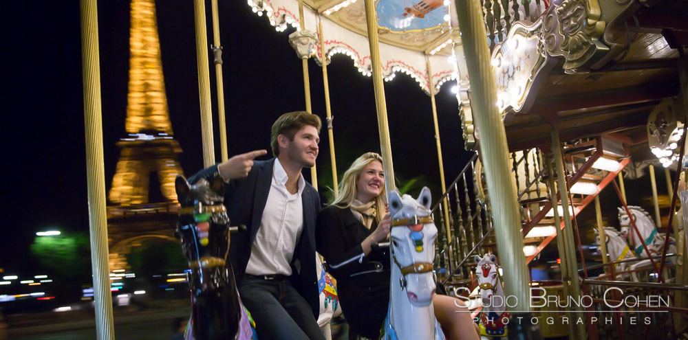 riding couple on horses from eiffel tower carousel at night proposal in paris