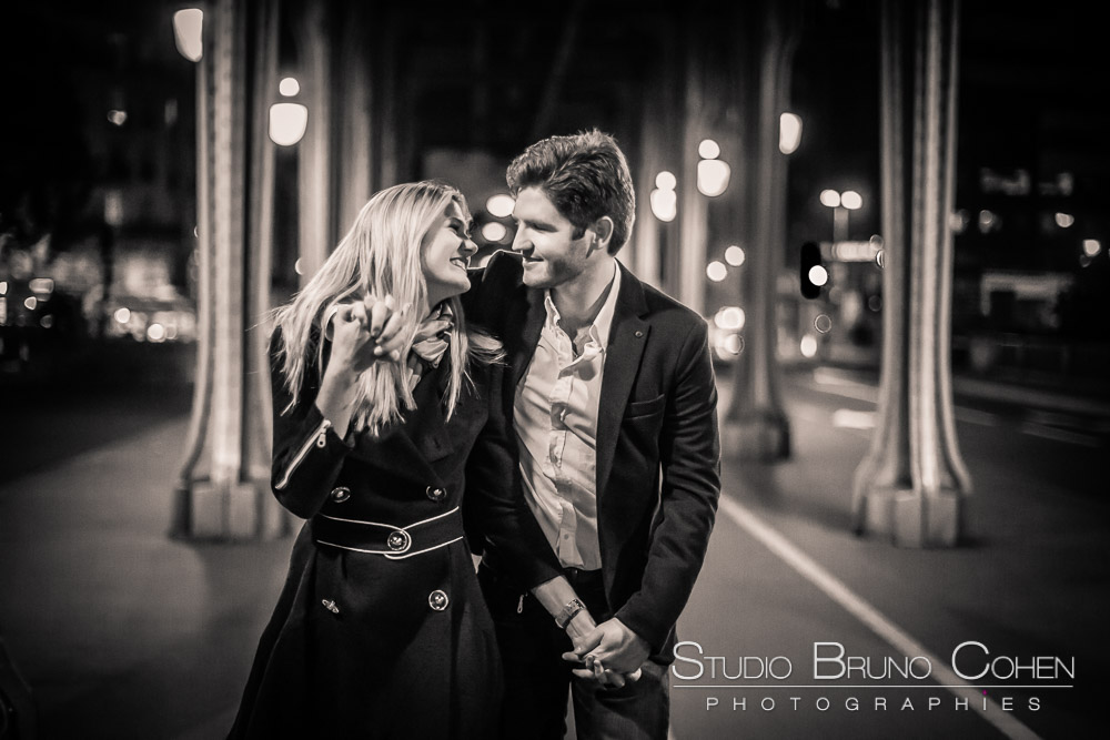 couple walk in love walk on bir hakeim bridge from paris at night