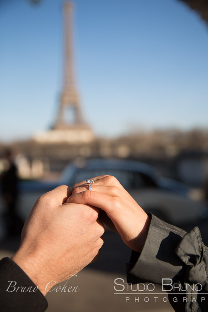 proposal in paris engagement ring focus at winter front of Eiffel Tower