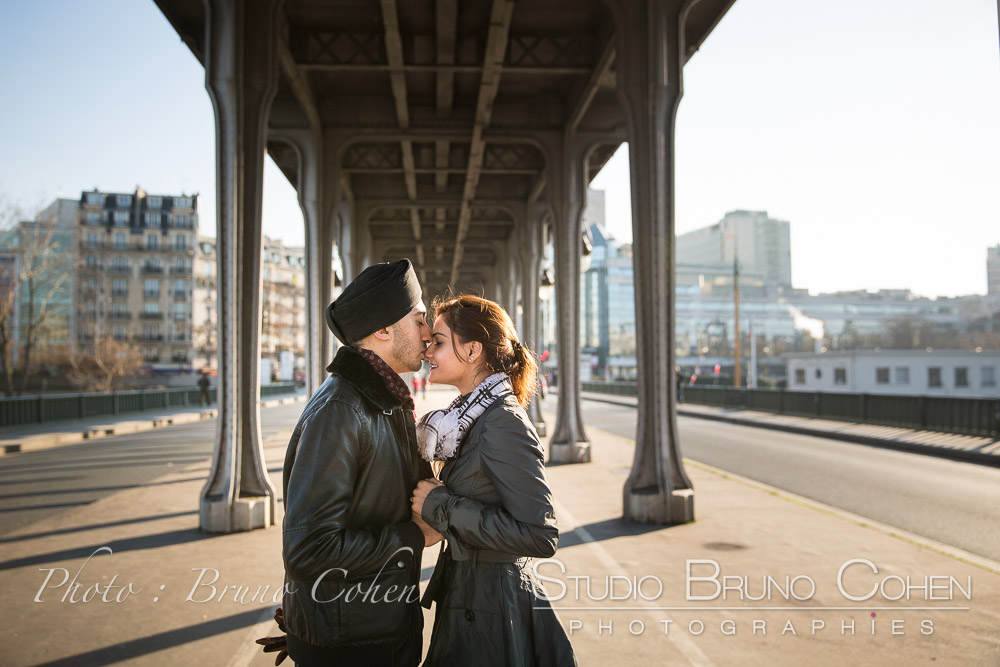 couple in love kiss forehead under Bir Hakeim bridge at winter paris proposal