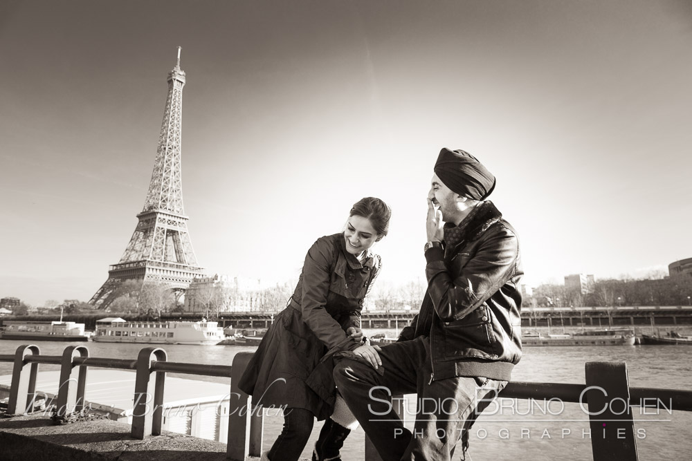 smiling couple on quai de seine front of Eiffel Tower in paris black and white