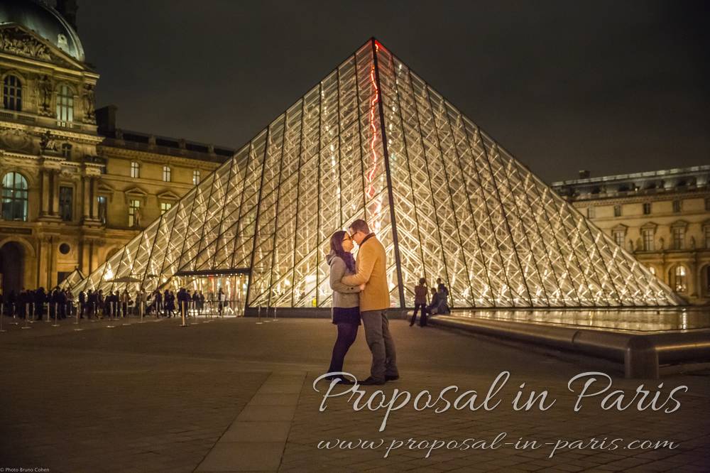 couple kissing after a proposal by the Louvre pyramid, Paris
