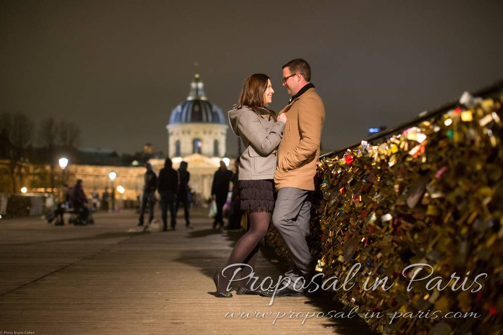 couple cuddling looking at each other on Pont de Arts, Paris