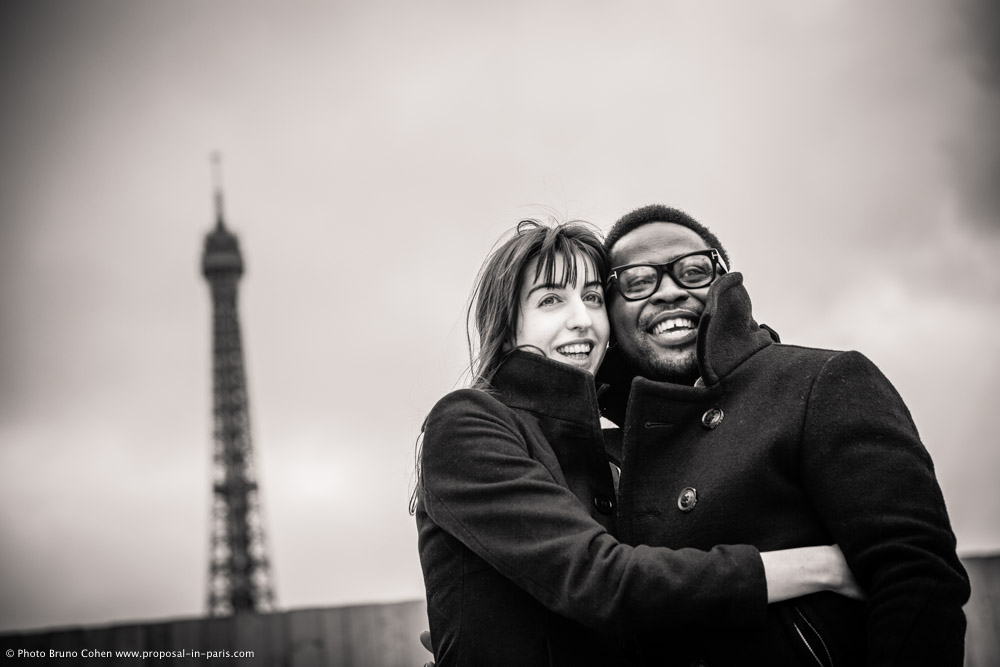 engagement session couple in love hugs from Trocadero front of Eiffel Tower in paris black and white