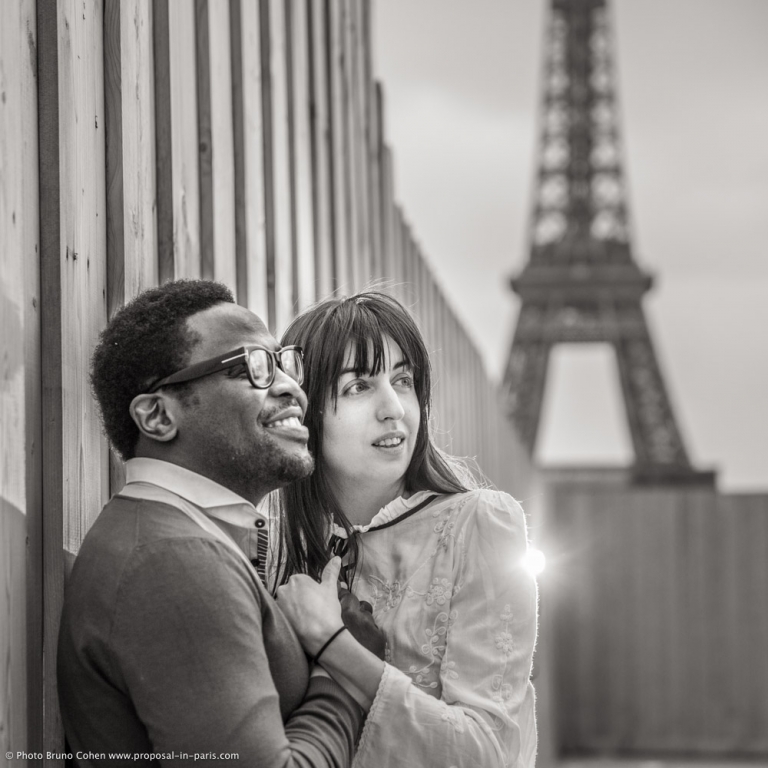 engagement session couple in love hugs from Trocadero front of Eiffel Tower in paris black and white