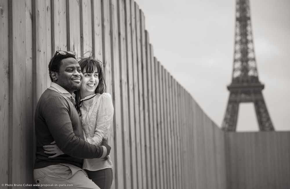 engagement session couple in love hugs from Trocadero front of Eiffel Tower in paris black and white