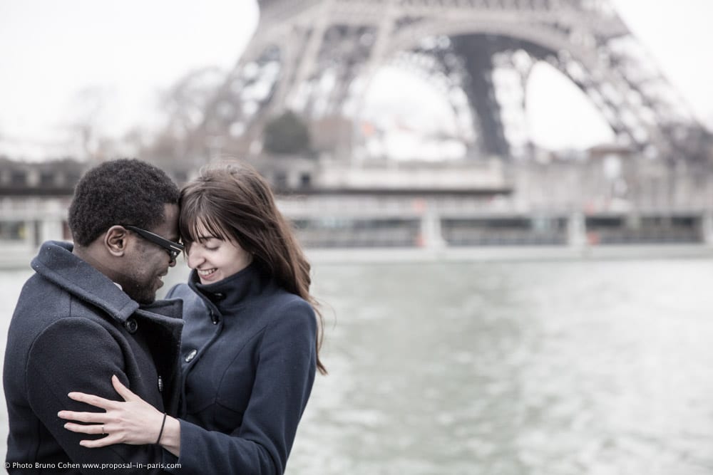 engagement session photographer paris Beloved couple face to face front of Eiffel Tower from seine banks 